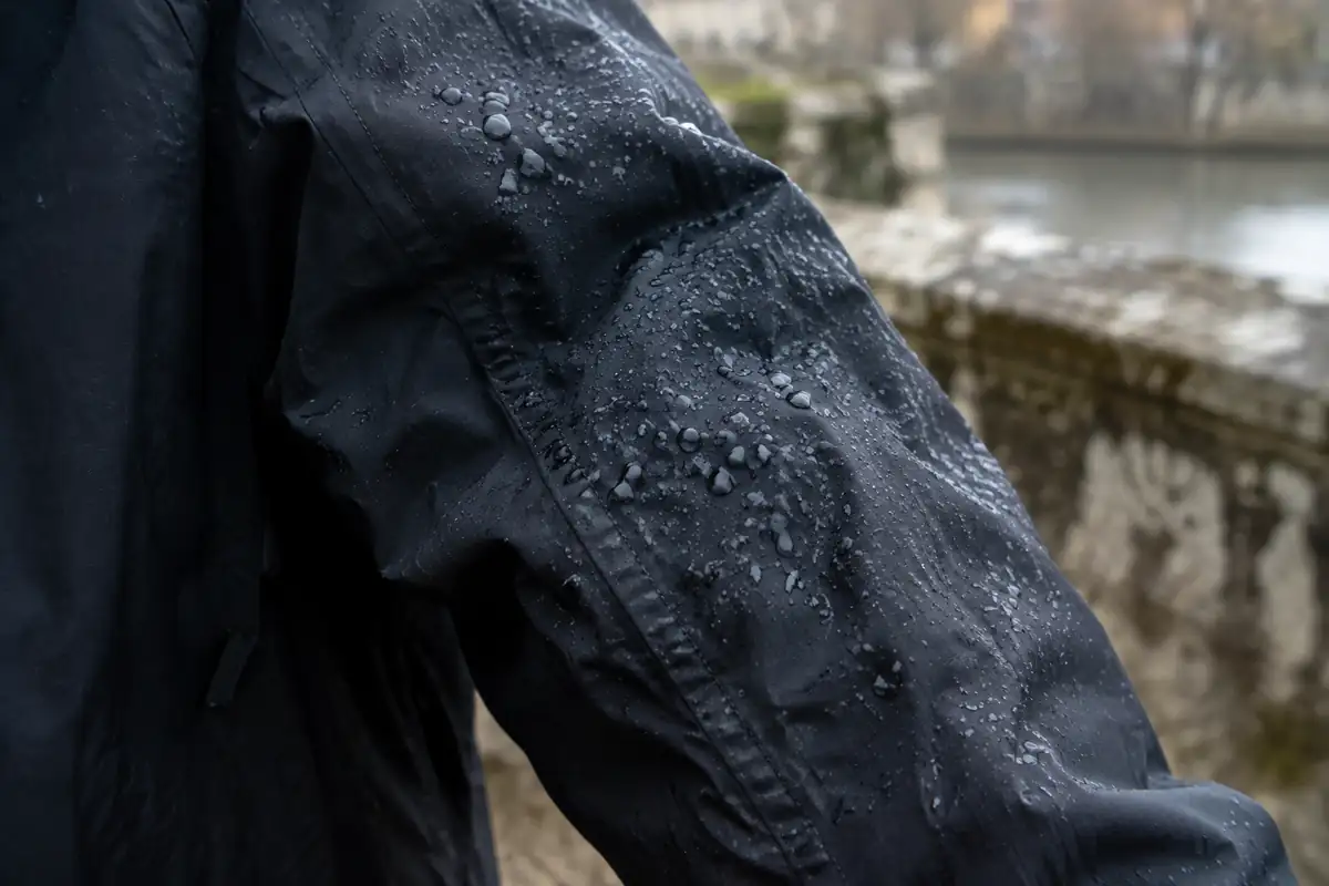 Gouttes d'eau qui perlent sur une manche de veste sombre