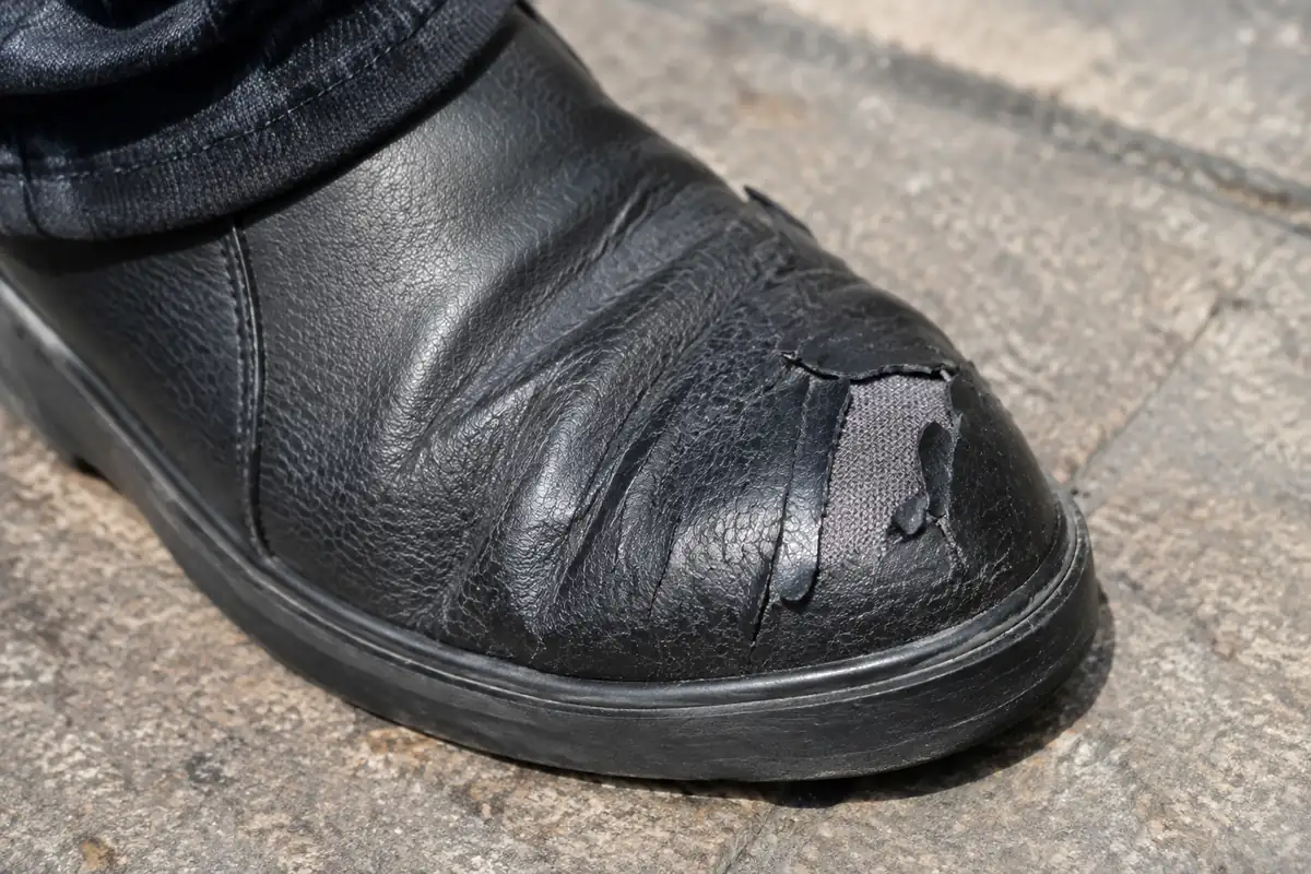 Chaussure synthétique dont le revêtement pèle au pli de l'avant-pied